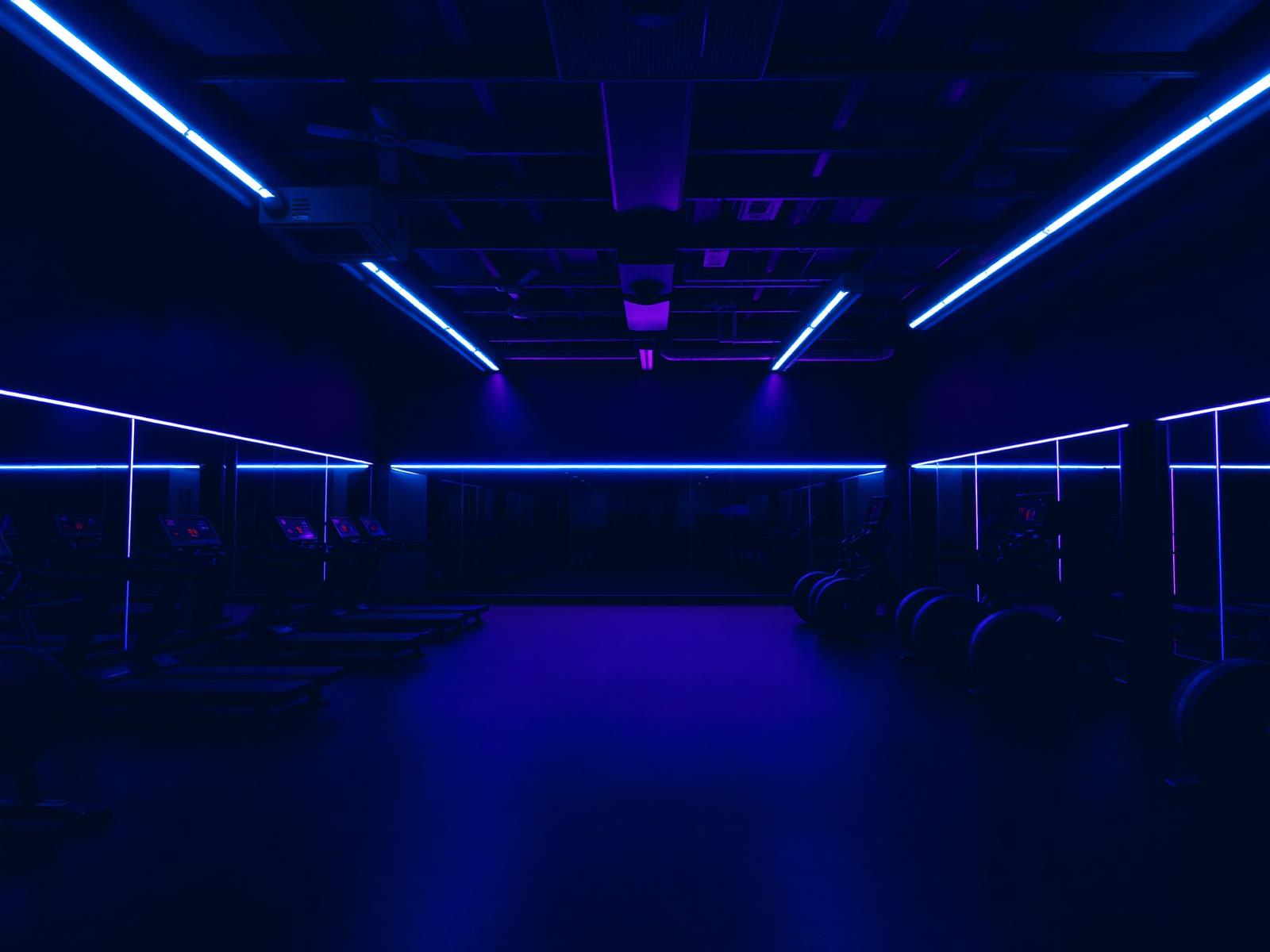 Gimnasio iluminado con luces de neón indigo